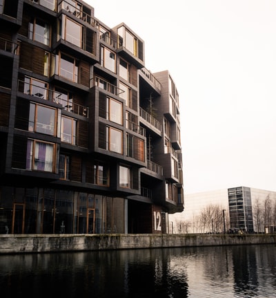 brown concrete building beside river during daytime